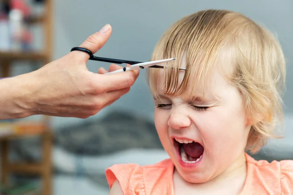 母親が家で散髪してる間に叫んでる女の子 — ストック写真