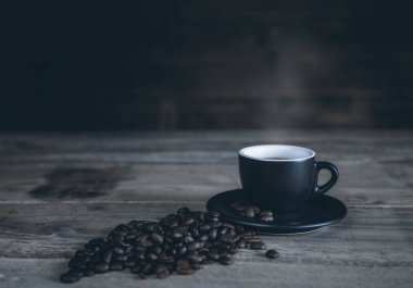 Sıcak kahve kahve çekirdekleri tahtaya koymak ile siyah Kupası