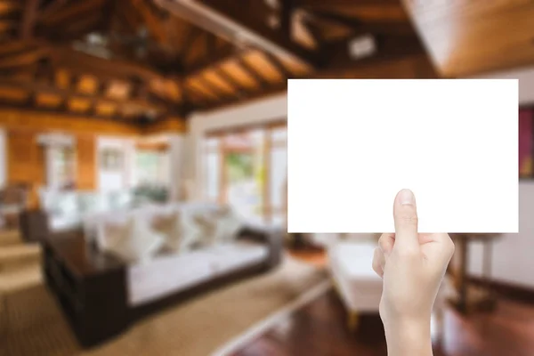 Mano sosteniendo papel en blanco con fondo interior — Foto de Stock