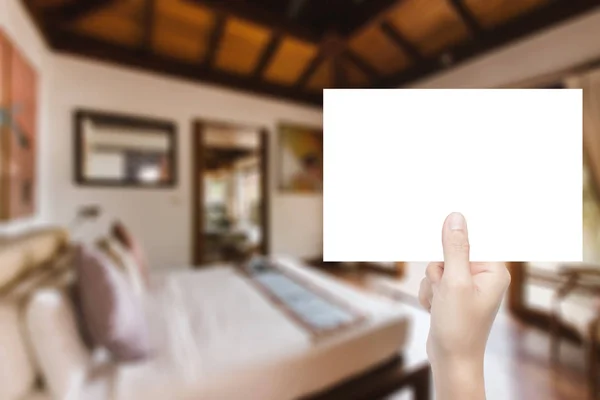 Mano sosteniendo papel en blanco con fondo interior — Foto de Stock