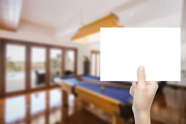 Mano sosteniendo papel en blanco con fondo interior — Foto de Stock