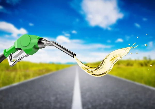 Buse de pompe à essence verte avec éclaboussure d'huile sur la route de voyage — Photo