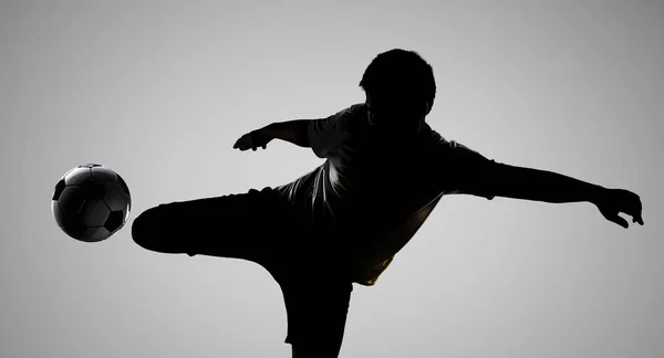 Silhouette soccer player kicking the ball — Stock Photo, Image