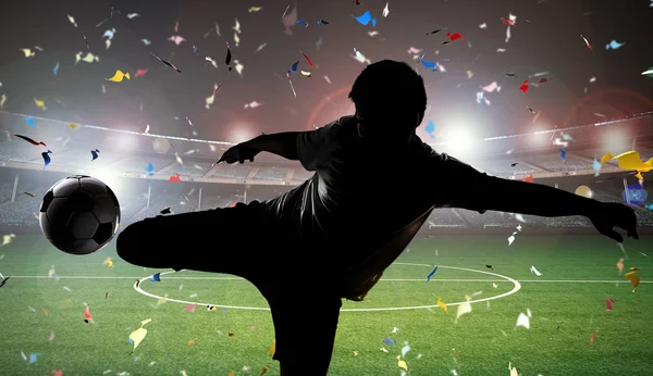 Silueta futbolista pateando la pelota — Foto de Stock