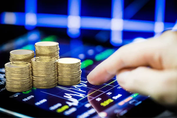 Stock market watching with digital tablet and stack of gold coin — Stock Photo, Image