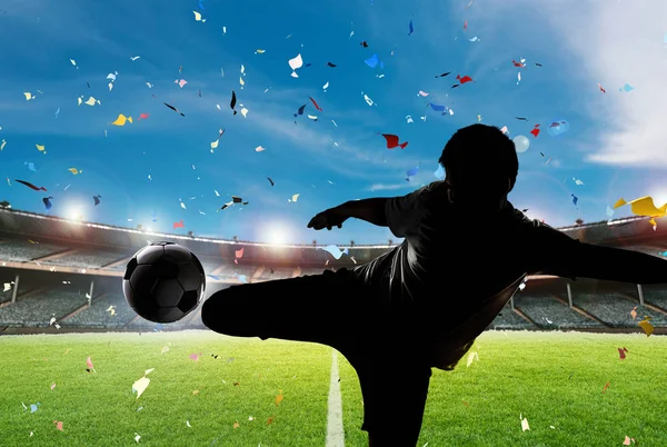 シルエットのサッカーの選手がボールを蹴る — ストック写真