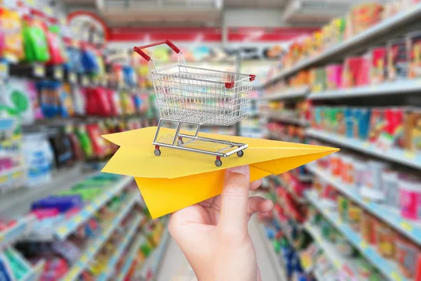 Goods delivery concept with paper plane shopping cart in superma — Stock Photo, Image