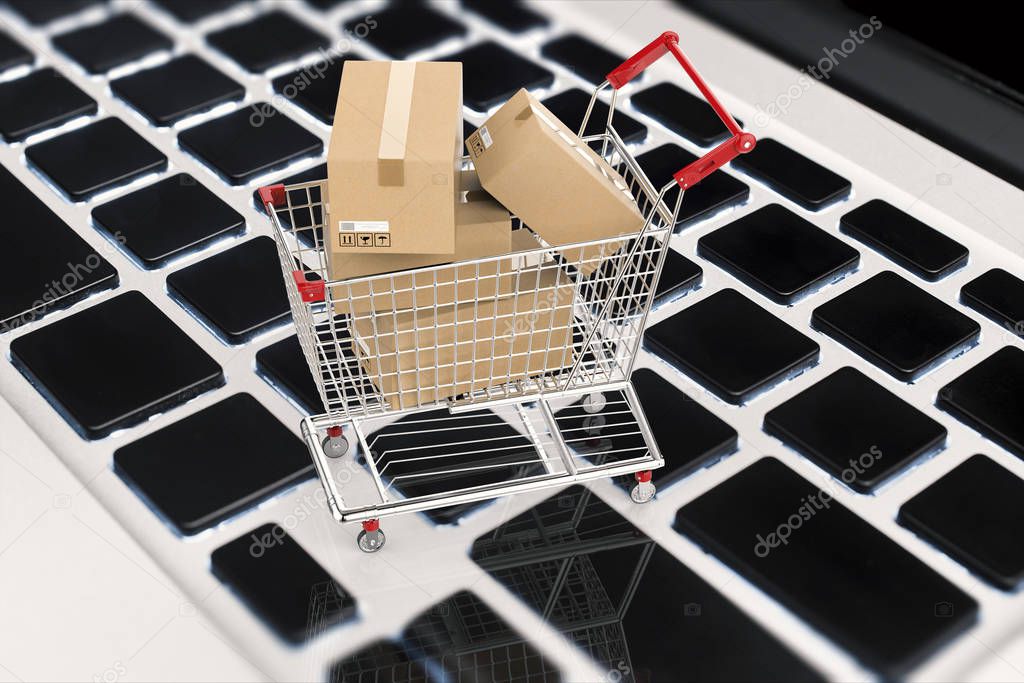 online shopping concept with carton boxes in shopping cart