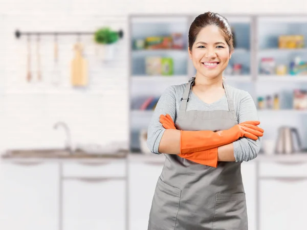 Aziatische huisvrouw dragen van rubberen handschoenen gekruiste armen — Stockfoto