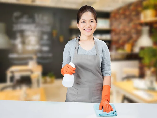 Asiatische Hausfrau fegen auf Tisch — Stockfoto