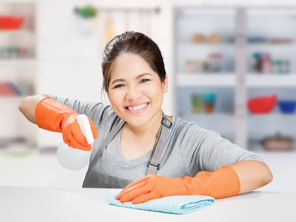 Asiatische Hausfrau fegen auf Tisch — Stockfoto