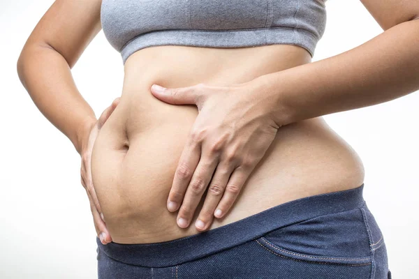 Mujer con sobrepeso con la mano sosteniendo la grasa del vientre —  Fotos de Stock