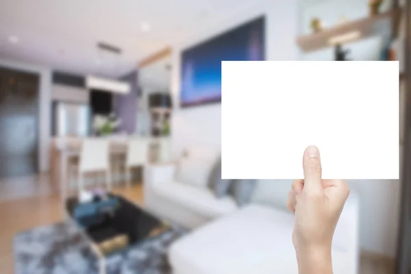 Mano sosteniendo papel en blanco con fondo interior — Foto de Stock