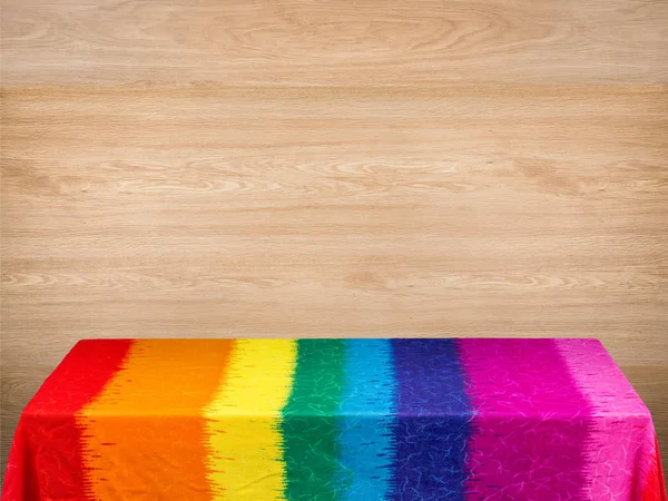 Regenbogen-Tischdecke auf Holz-Hintergrund — Stockfoto