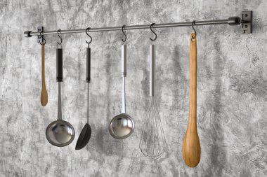 Mutfak rafında mutfak aletleri asılı. 