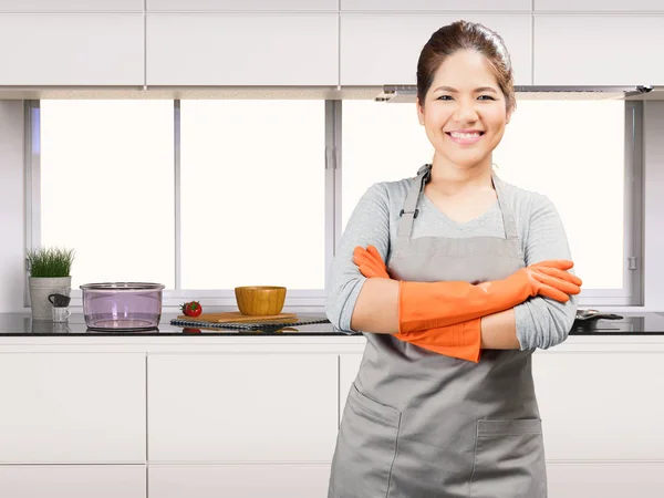 Asiatische Hausfrau mit Gummihandschuhen — Stockfoto