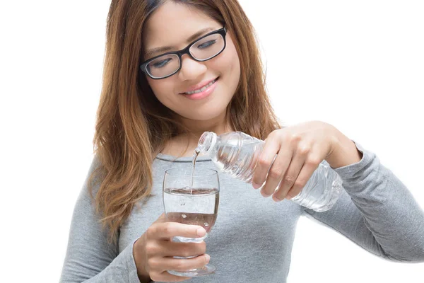 Wanita muda menuangkan air ke dalam gelas — Stok Foto