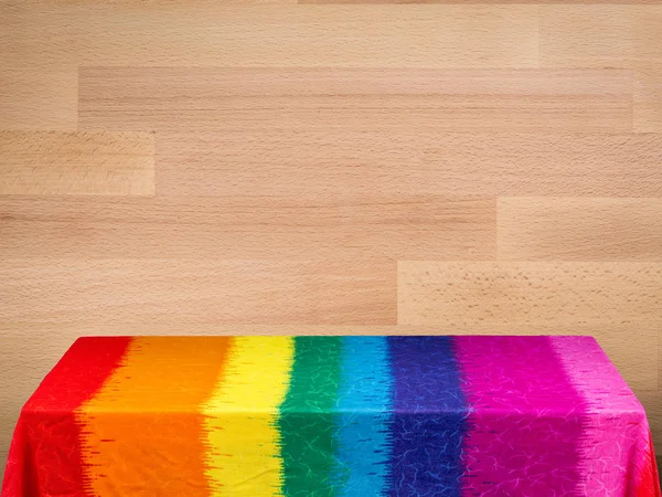 Regenbogen-Tischdecke auf Holz-Hintergrund — Stockfoto