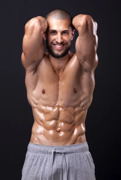 Sonriente hombre en forma flexionando el abdomen — Foto de Stock