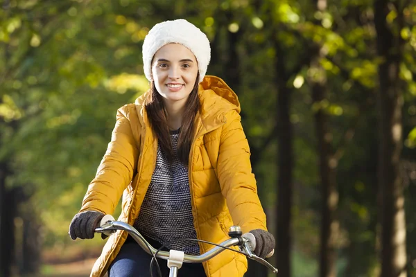 Vacker kvinna på cykel i höst park — Stockfoto