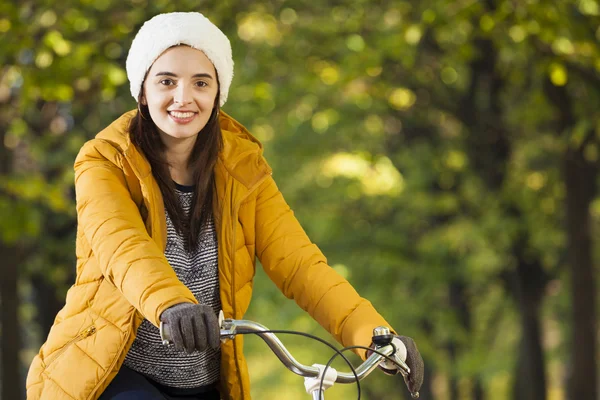 Mujer de pie en bicicleta en el parque de otoño —  Fotos de Stock