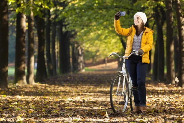 Fille à vélo prendre des photos avec téléphone portable à l'extérieur — Photo