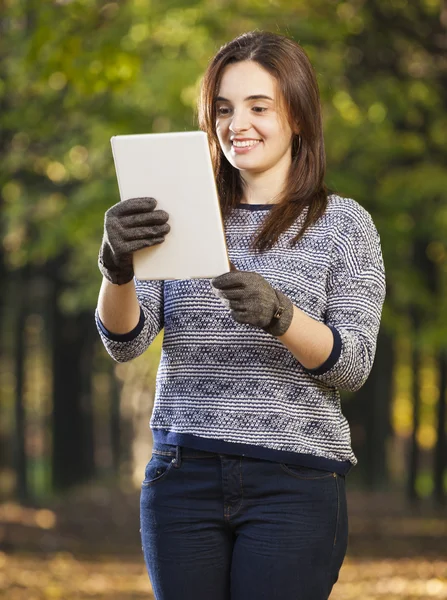 Vrouw met de tablet pc in de herfst park — Stockfoto