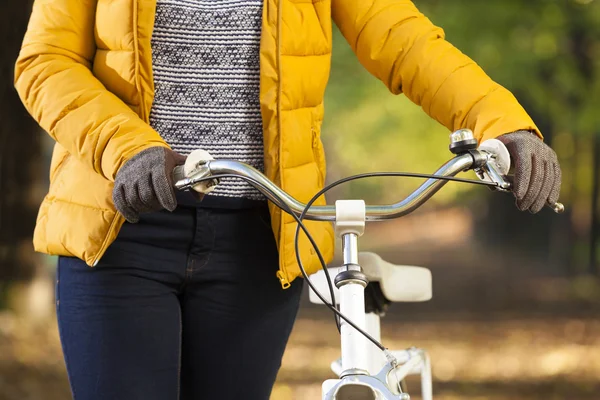 Chica caminando con una bicicleta en el parque —  Fotos de Stock