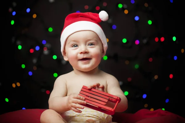 クリスマス サンタ帽子のそりを保持している赤ちゃん — ストック写真