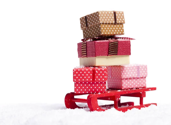 Roter Schlitten voller Geschenkboxen im Schnee — Stockfoto