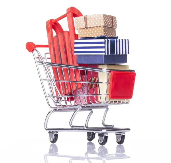 Shopping cart with gift boxes and sled — Stock Photo, Image