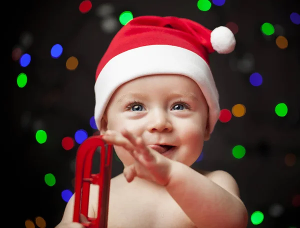 そりを持ってサンタ帽子でかわいい赤ちゃん — ストック写真