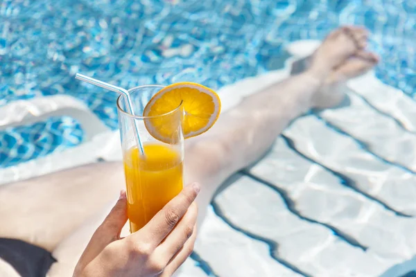 Femme dégustant un jus d'orange à la piscine — Photo