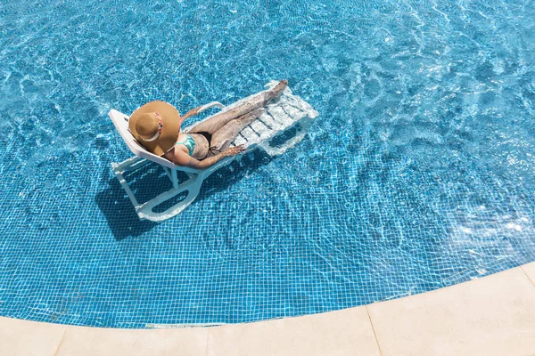 Frau entspannt sich auf Liegestühlen im Schwimmbad — Stockfoto