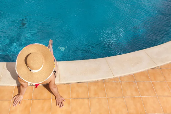 Femme assise au bord de la piscine — Photo