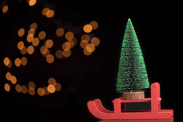 Red sled carrying a pine tree — Stock Photo, Image