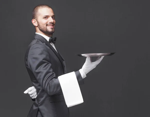 Щасливий офіціант тримає срібний піднос — стокове фото