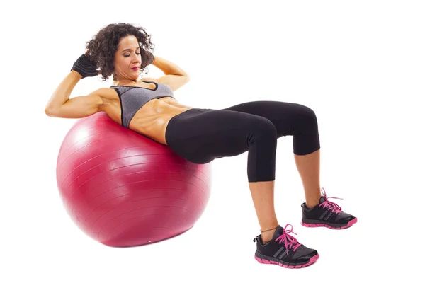 Mujer joven haciendo abdominales en una bola en forma — Foto de Stock