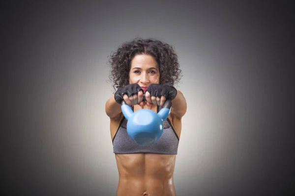 Attractive female doing kettle bell exercise — Stock Photo, Image