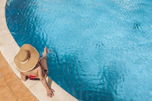 Mulher sentada na beira da piscina — Fotografia de Stock