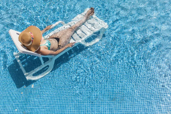 Mulher tomando banho de sol na piscina — Fotografia de Stock