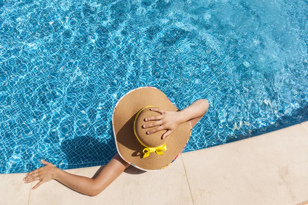 Femme méconnaissable en chapeau relaxant sur la piscine — Photo