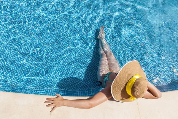 Femme bronzée en chapeau relaxant sur la piscine — Photo