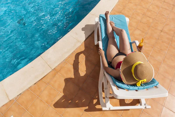 Молодая женщина отдыхает у бассейна с соком — стоковое фото
