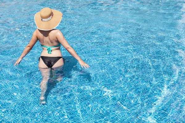 Mulher de chapéu dentro da piscina — Fotografia de Stock