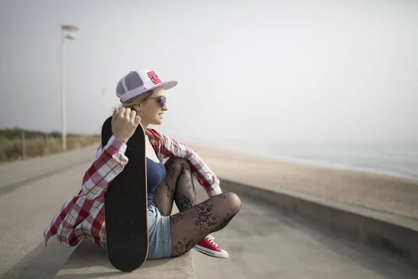 Moda jovem posando com um skate — Fotografia de Stock