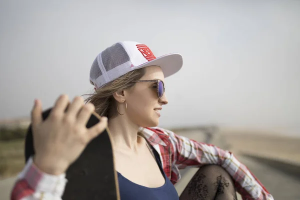 Beautiful young woman posing with a skateboard — Stock Photo, Image