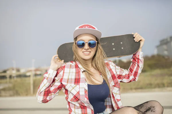 Mulher bonita segurando um skate — Fotografia de Stock