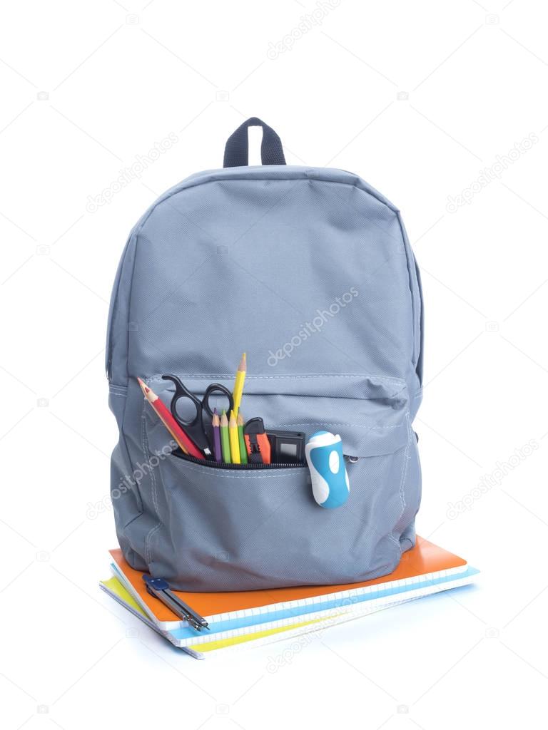 Backpack with school supplies on top of notebooks