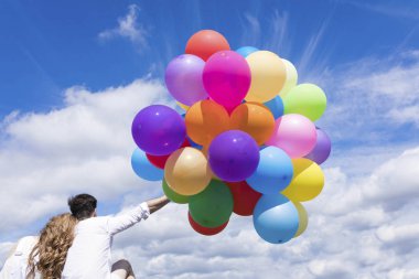 Genç çift holding renkli balonlar